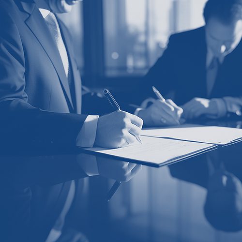 Two people signing contracts