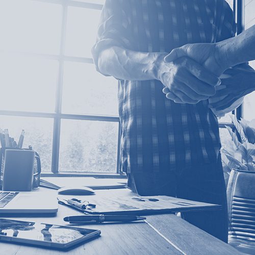 Two people shaking hands to show business investment together